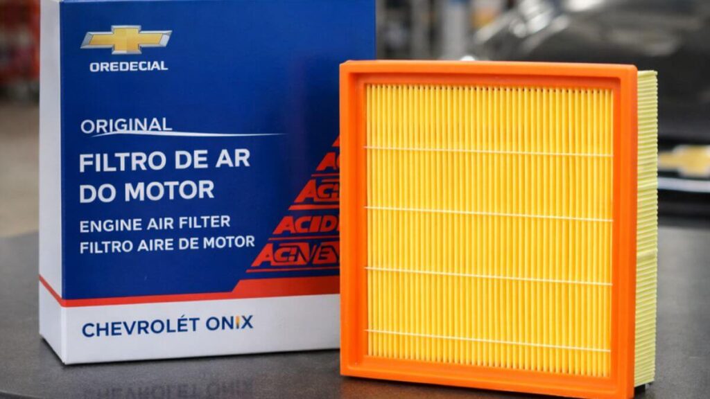 Filtro de ar do motor do Chevrolet Onix novo sobre mesa de oficina ao lado da caixa do produto