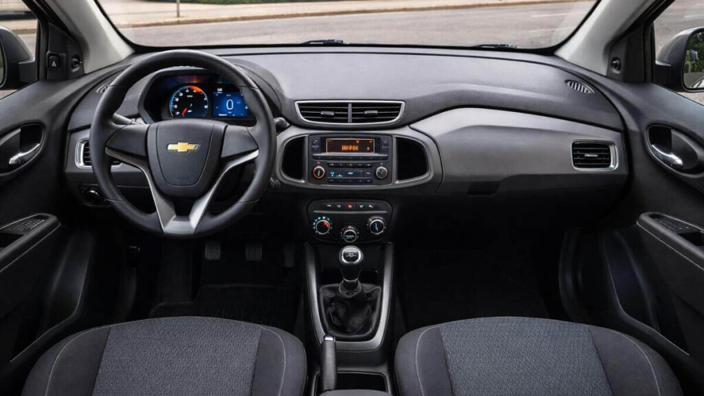 Interior do Chevrolet Onix 2012 com acabamento simples, funcional e painel central