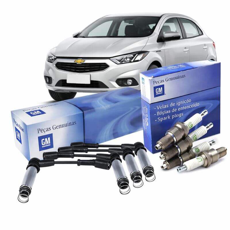 Kit original GM com velas e cabos de ignição para Chevrolet Onix, com peças e caixas genuínas ao fundo do veículo.