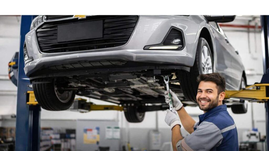 Imagem do Chevrolet Onix moderno em uma oficina, elevado em um elevador, com mecânico sorridente realizando manutenção preventiva. O carro está centralizado, lateral visível e boca do tanque corretamente posicionada, transmitindo cuidado e durabilidade.
