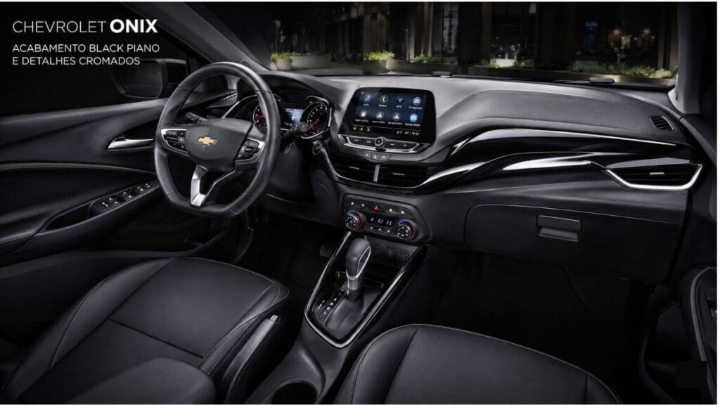 Interior do Chevrolet Onix preto com acabamento Black Piano e detalhes cromados no painel central, console do câmbio, maçanetas internas e saídas de ar.