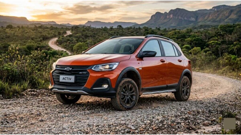 Chevrolet Onix Activ 2027 laranja posicionado de ângulo em uma estrada de pedras e terra, destacando a suspensão elevada, pneus para todo tipo de terreno e protetores de para-choque plásticos.